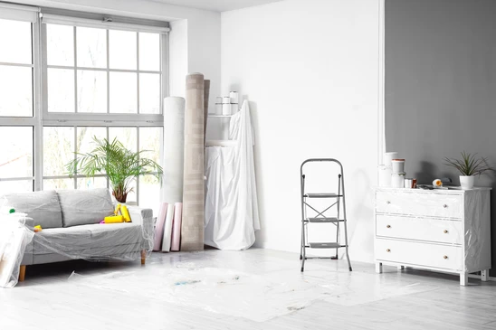 Int&eacute;rieur d'atelier, artisan posant carrelage blanc sur sol, mains expertes positionnant carreau avec pr&eacute;cision