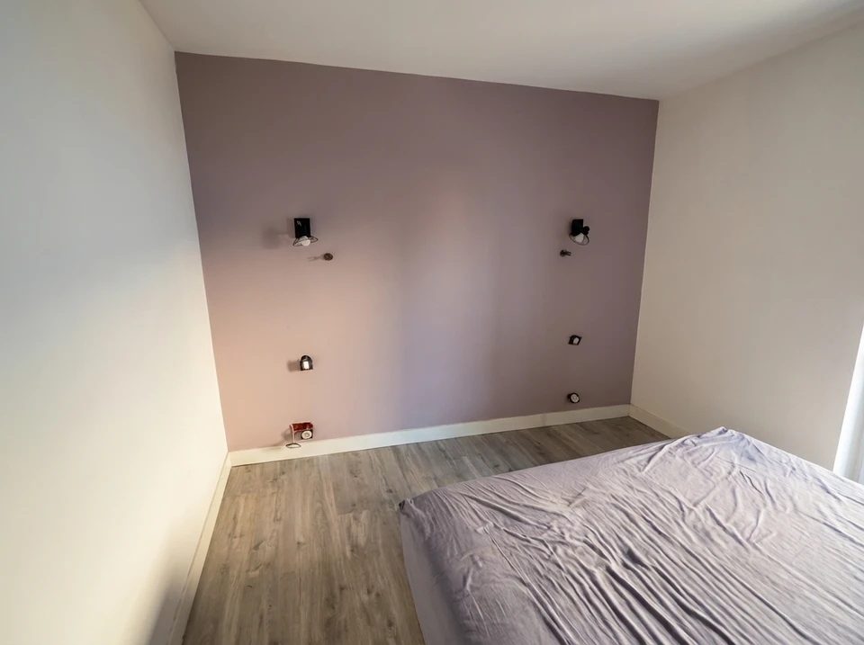 Travailleur manuel de 30 ans avec des outils de plâtrage mural rénovent la maison